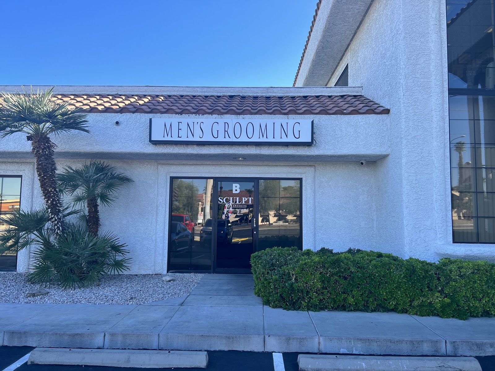 Storefront exterior with 'MEN'S GROOMING' sign and SCULPT window logo