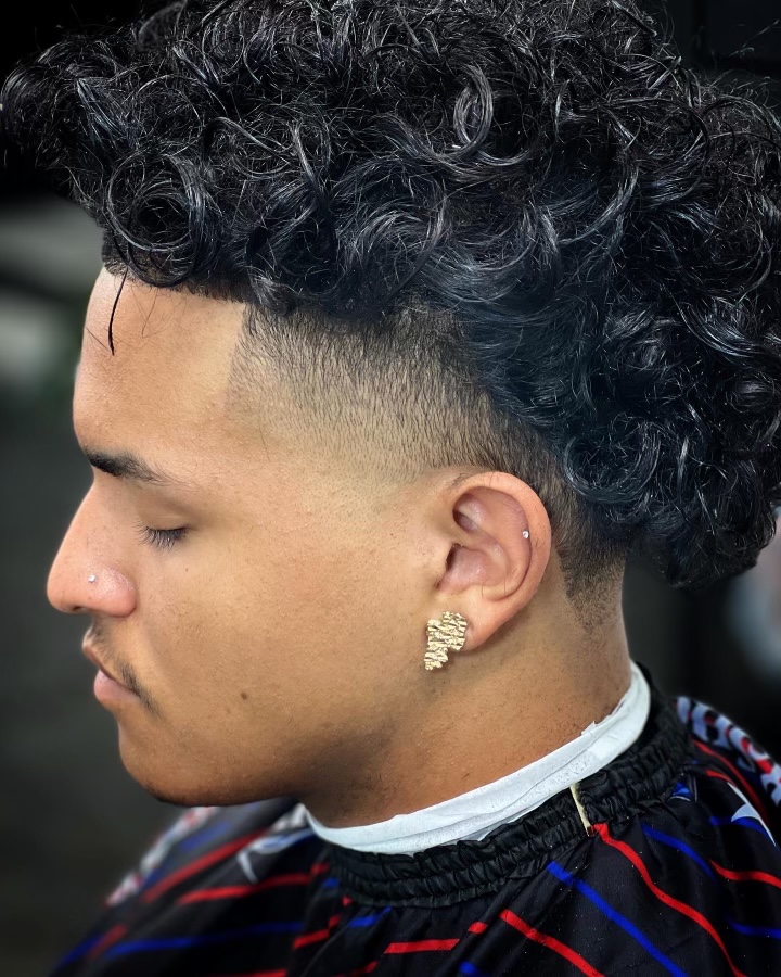 Curly top with a burst fade and clean line-up shown in profile